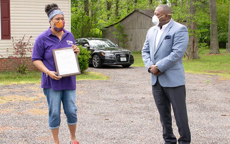 Tarri Jones accepts plaque from Superintendent Dr. George Parker.